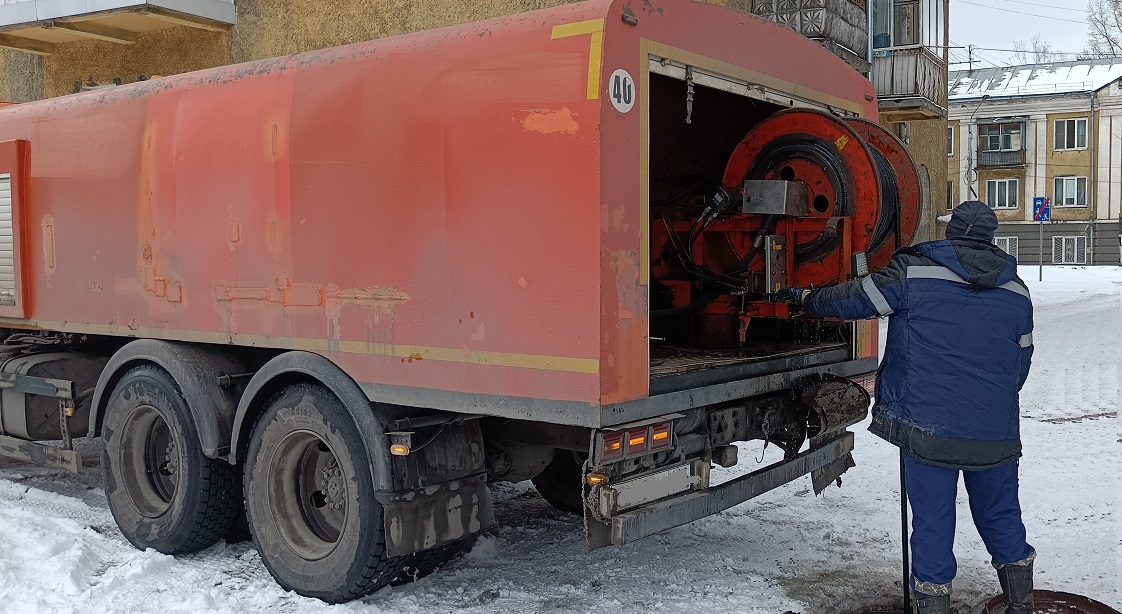 Каналопромывочная машина и работник прочищают засор в канализационной системе в Меленках